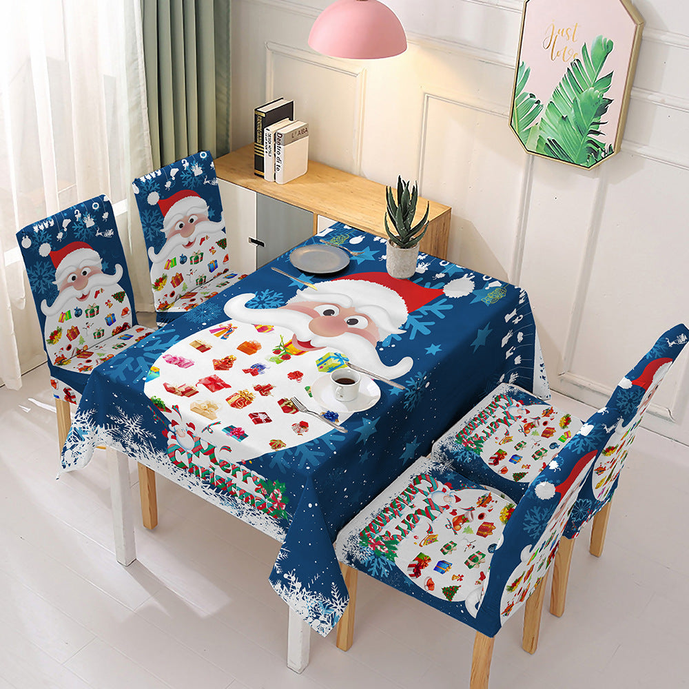 Festive Christmas dining table decor featuring Santa Claus and gift designs on a blue tablecloth and chair covers