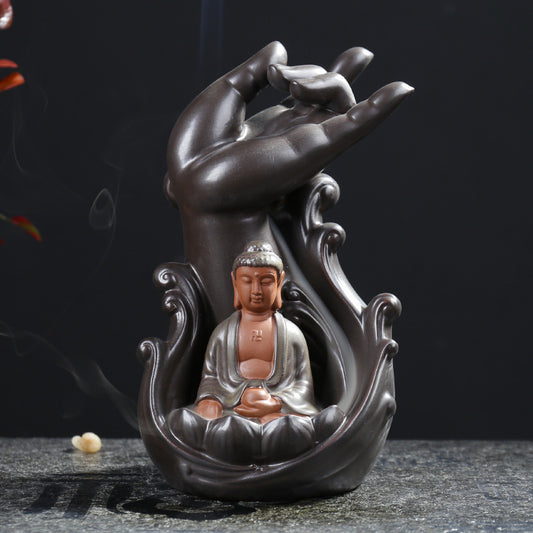 Creative incense burner featuring a hand sculpture with a seated Buddha and flowing smoke for relaxation
