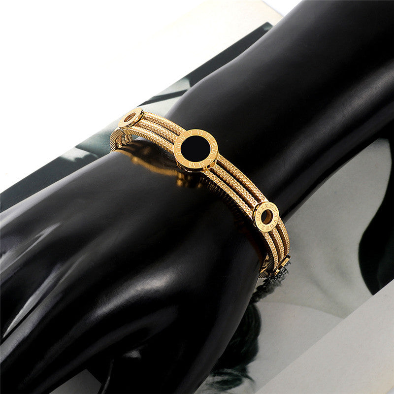 Stylish gold fashionable steel bracelets online displayed on a mannequin hand
