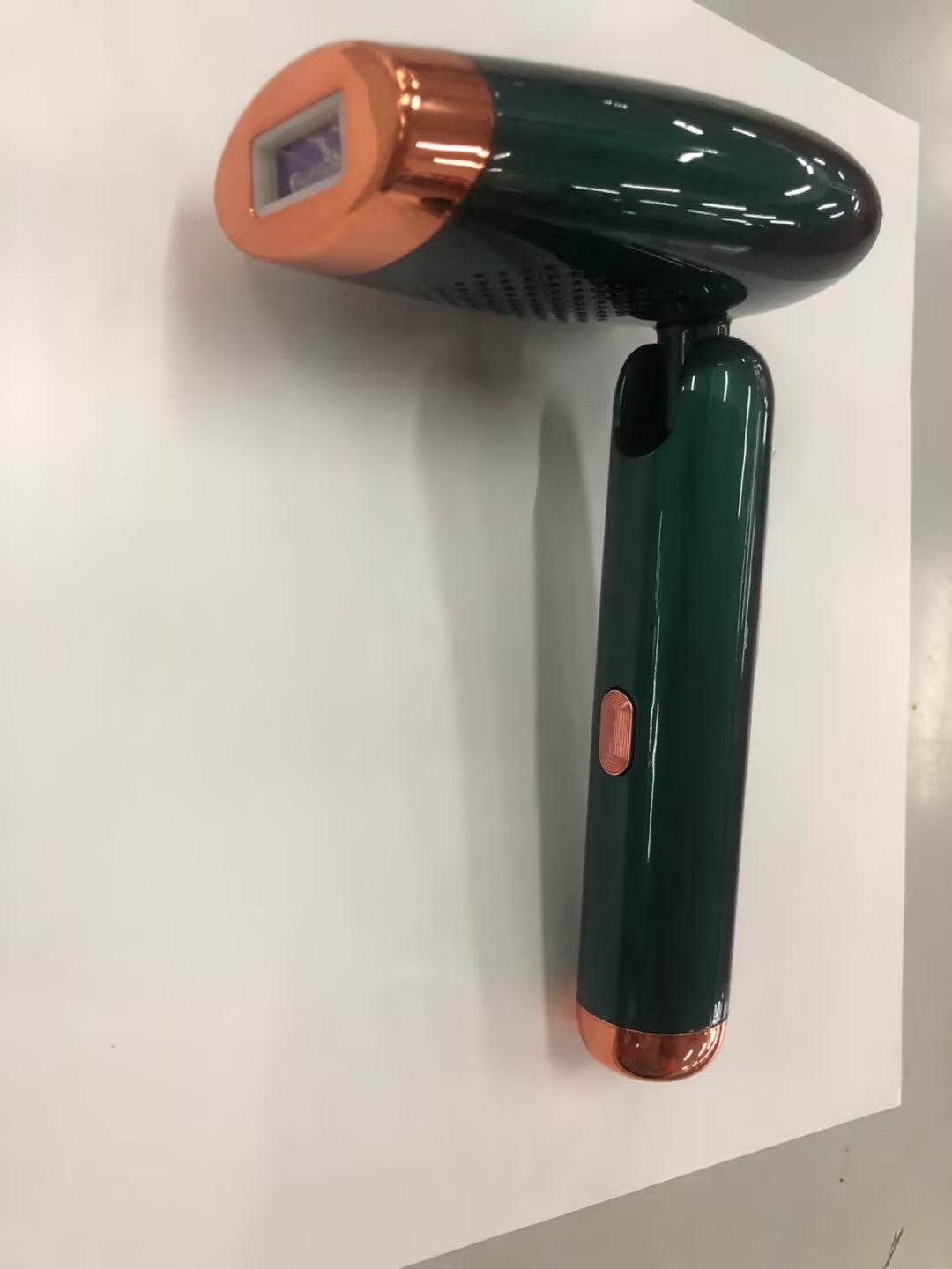 Folding IPL Hair Removal Device in green and copper with ergonomic handle for easy use