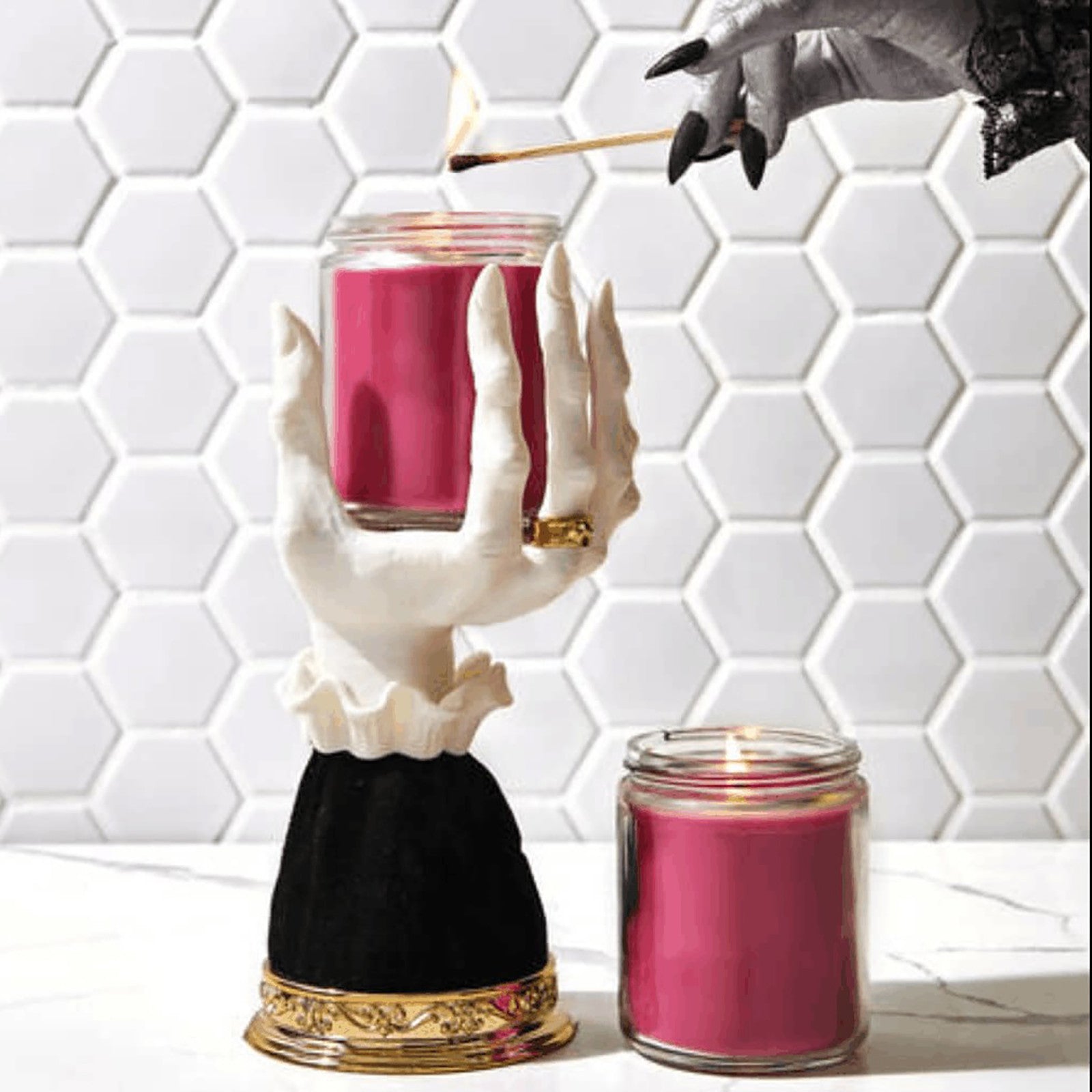 Halloween seat candlestick featuring a spooky hand design holding a pink candle