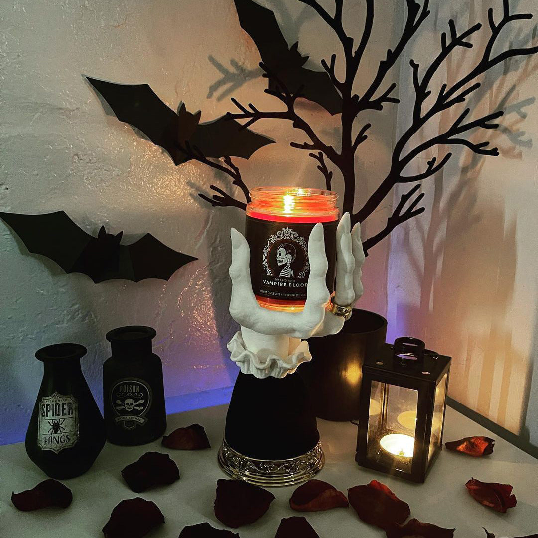 Halloween seat candlestick with spooky hand design and glowing candle for festive decor