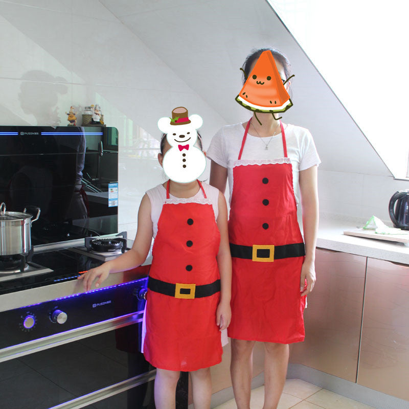 Two people wearing Santa Claus kitchen aprons in a festive kitchen setting
