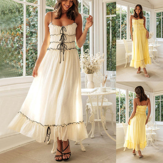 Woman wearing summer spaghetti strap dress in white with black trim and yellow variations for a stylish look