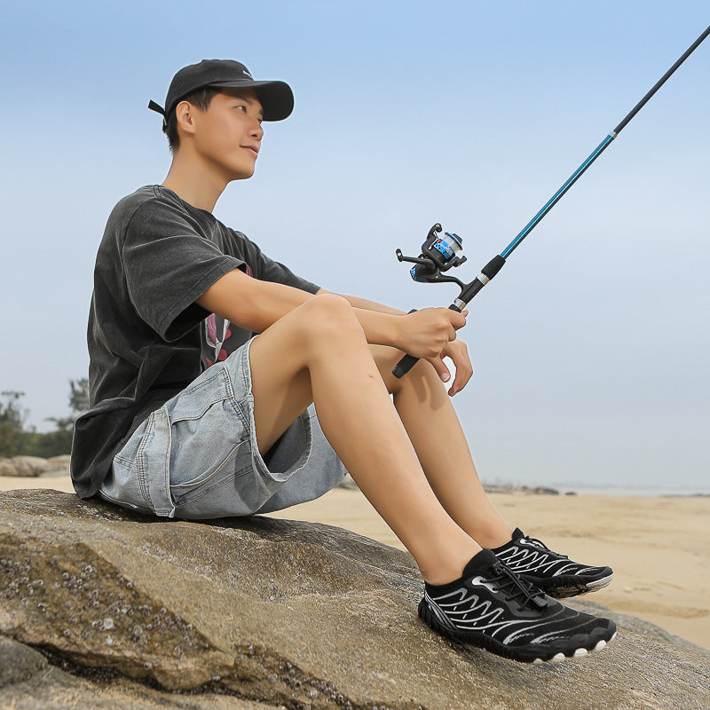 YouBuyForMe trekking non-slip shoes worn by a man fishing on a rocky beach
